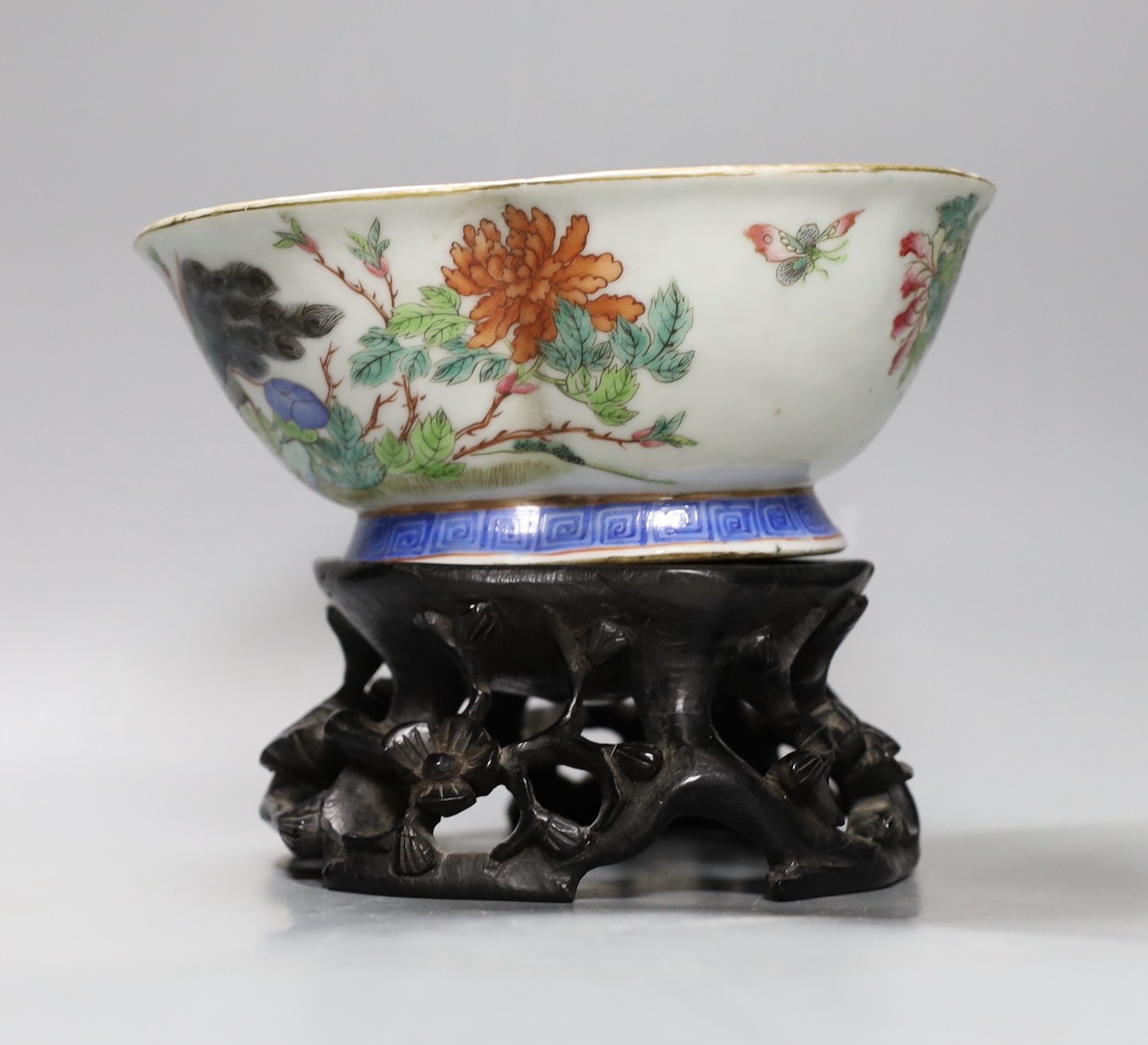 A Chinese Tongzhi famille rose dish with floral and bird decoration on carved stand, 14cm tall overall